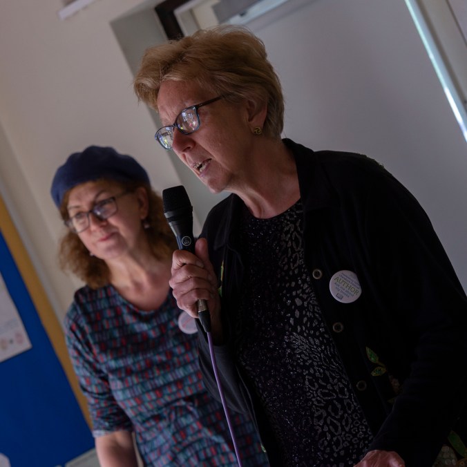 photo of Shirley Wright speaking at the opening ceremony with Debbie Young