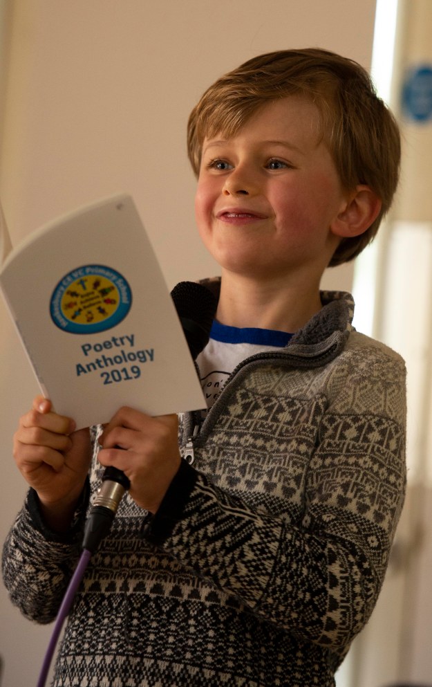 photo of small boy proudly reading his poem