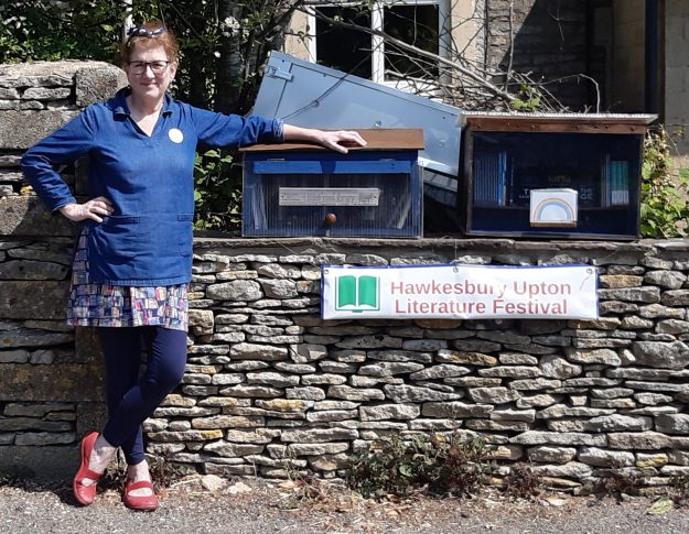 Photo of Debbie Young with book boxes and banner